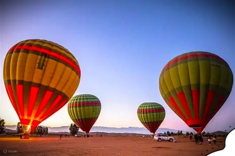 Hot air balloon rides over desert camps in Morocco offering panoramic views of the golden Sahara dunes.