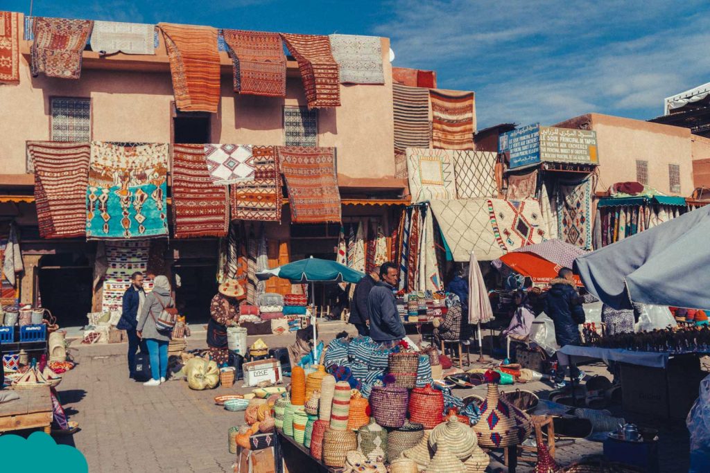 How to Negotiate in Marrakech Souks — travelers bargaining in colorful souks with spices, textiles, and lanterns