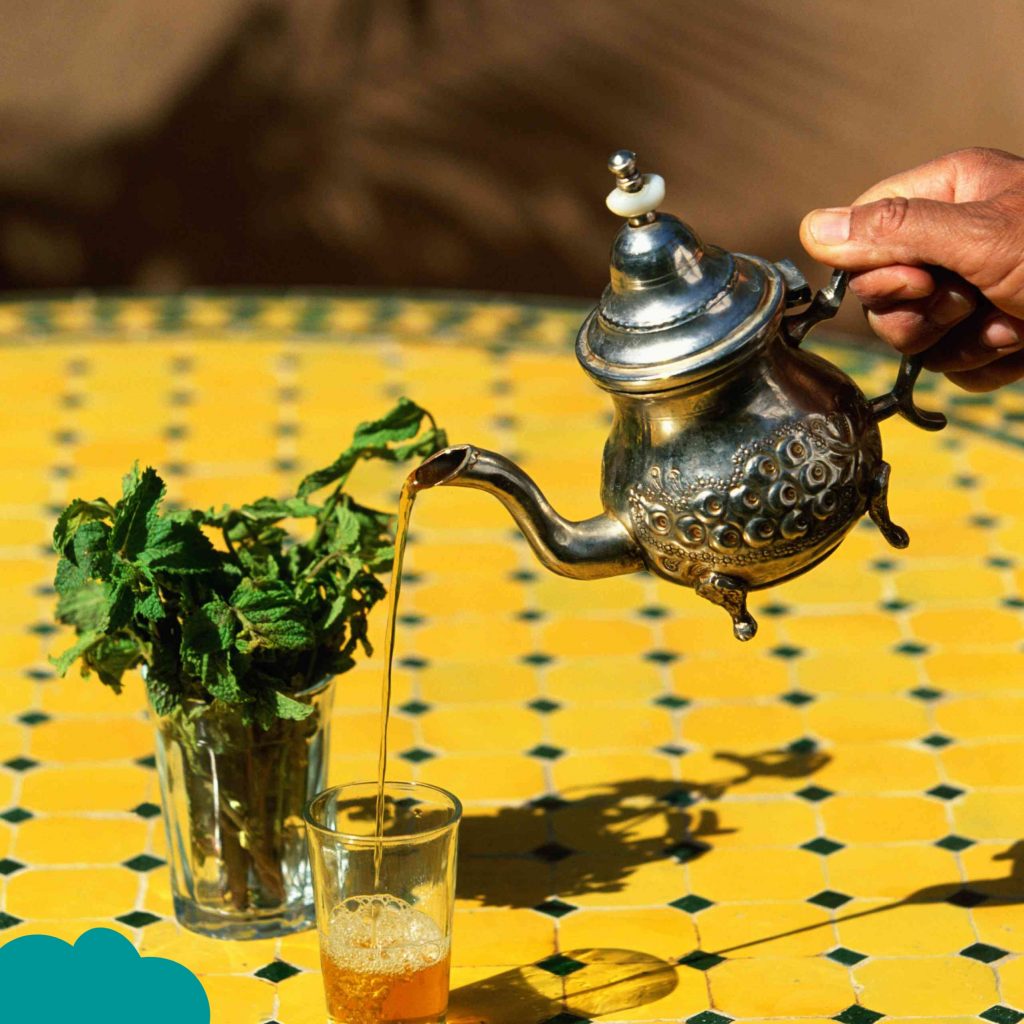 Moroccan Cuisine Must-Try Foods mint tea being poured into glasses with fresh mint leaves