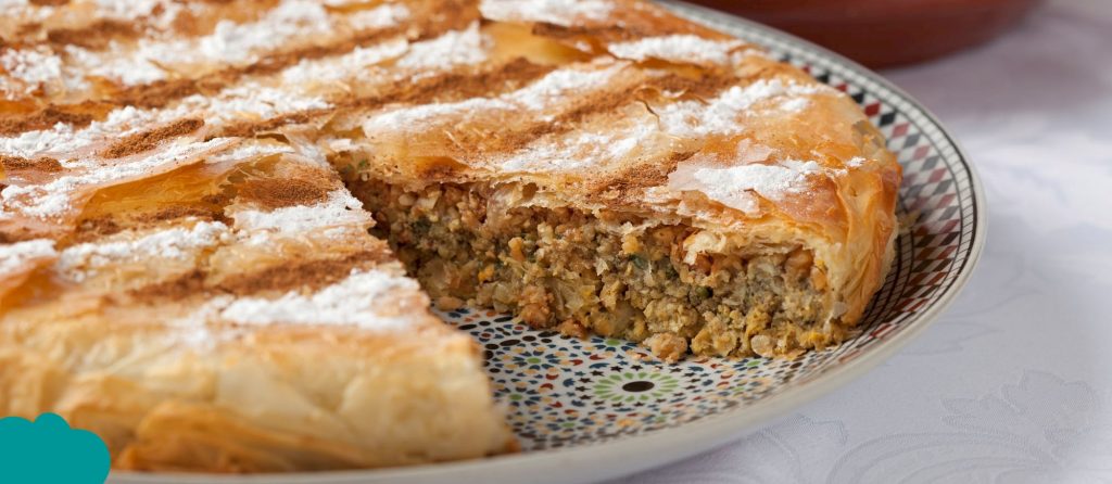 Moroccan Cuisine Must-Try Foods chicken pastilla topped with powdered sugar and cinnamon