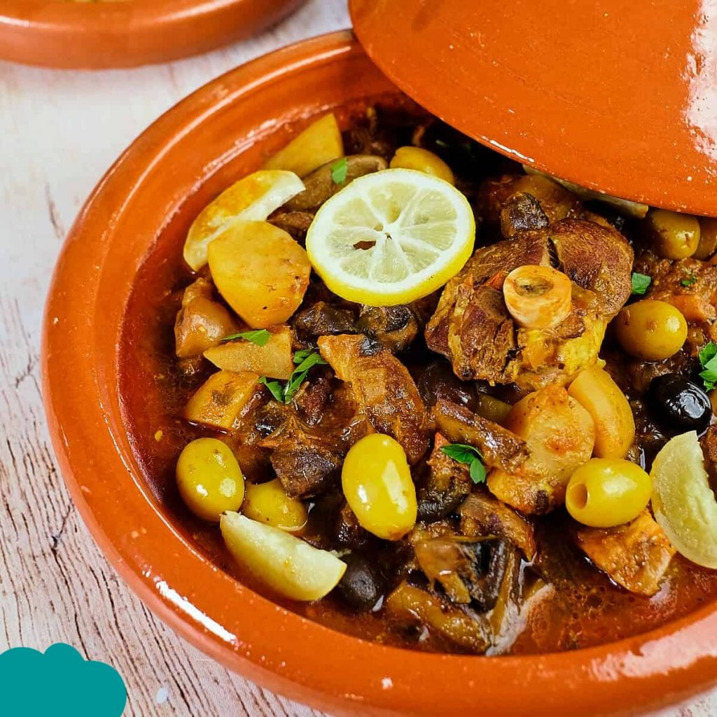 TMoroccan Cuisine Must-Try Foods tagine with chicken, preserved lemons, and olives served in a clay pot