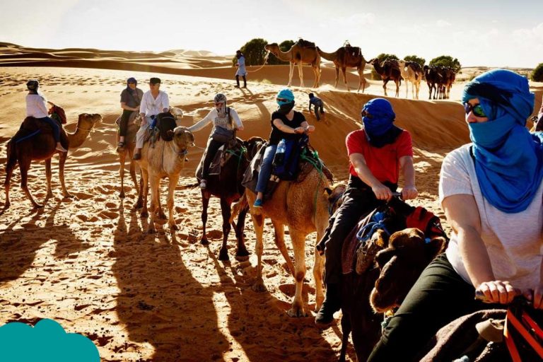 Traveler in Morocco travel outfits enjoying Sahara Desert sunset
